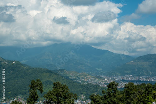 Aerial view of Pokhara city  Nepal  with surrounding hills and white cumulus clouds above them