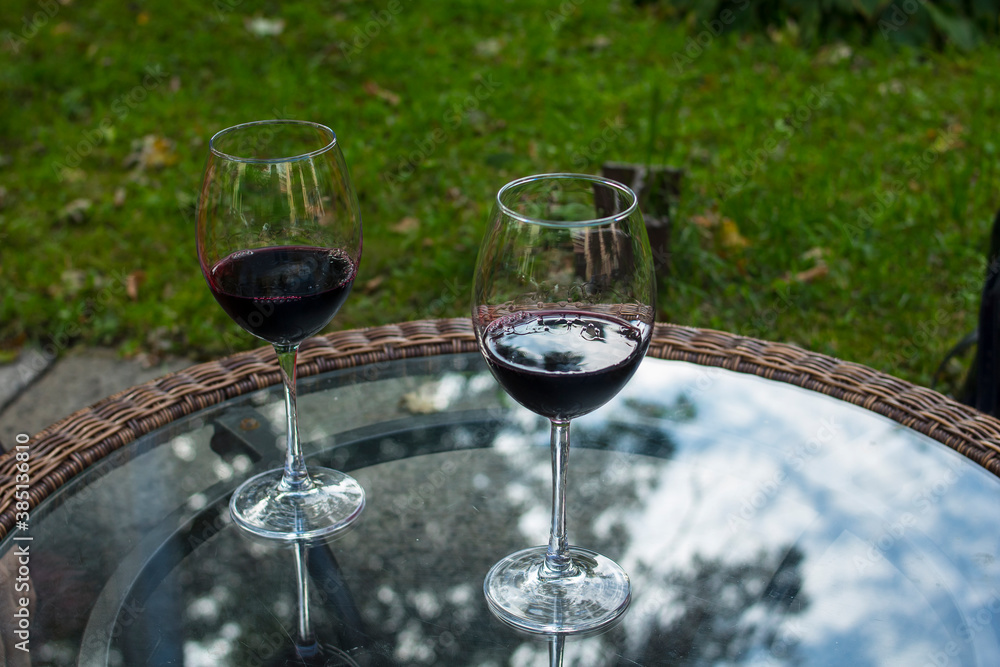 Glasses with red wine on a transparent glass table
Glasses with red wine on a transparent glass table