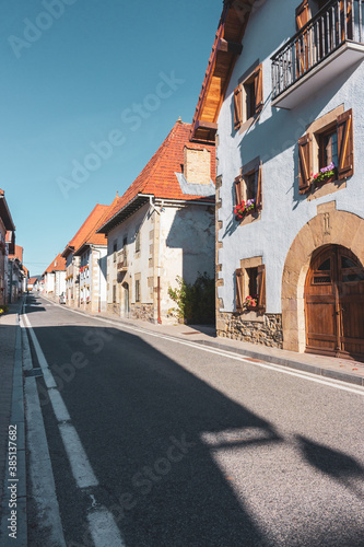 Empty street of old town in Europe. Medieval village on sunny day. Ancient buildings with flowers, toned. Empty road of historic downtown. Travel concept. Camino de Santiago route. 