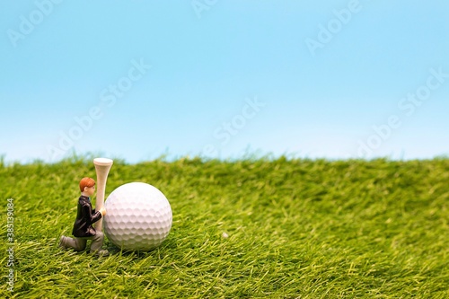 Golf wedding with golf ball and tee are on green grass with blue sky background