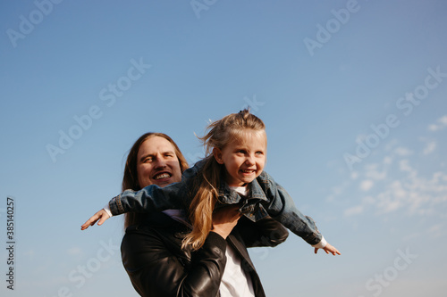 Cheerful father playing with little daughter outdoors