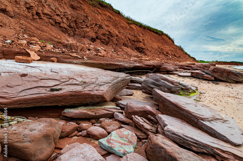 Red sandstone cliff and rocks at Cavendish beach of Prince Edward Island photo