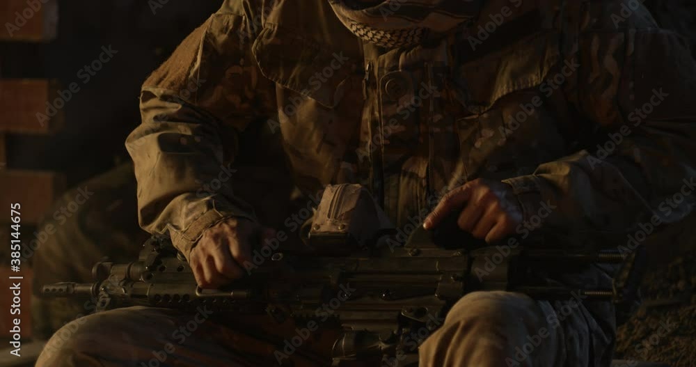 Soldier assembling gun near campfire Soldier assembling gun near campfire