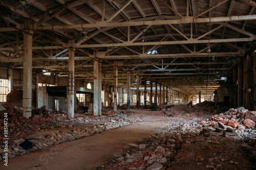 Abandoned ruined large industrial hall with garbage waiting for demolition