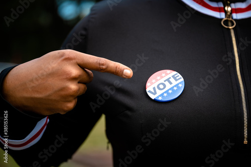 Hispanic Woman Pointing At A Vote Button