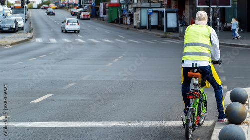 Man on the road on a small green bicycle