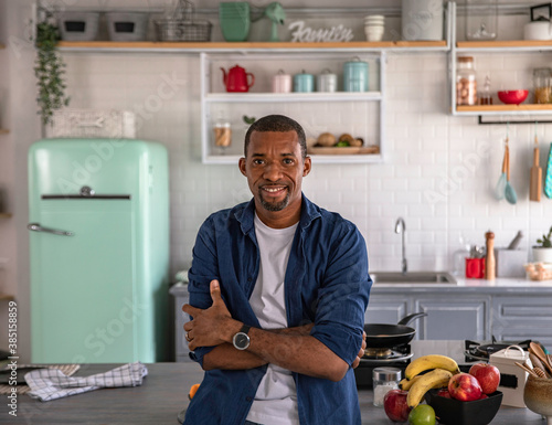 Portrait of a black man sitting on kitchen counter photo