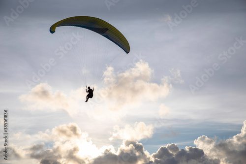 A paraglider flies high above a lake photo