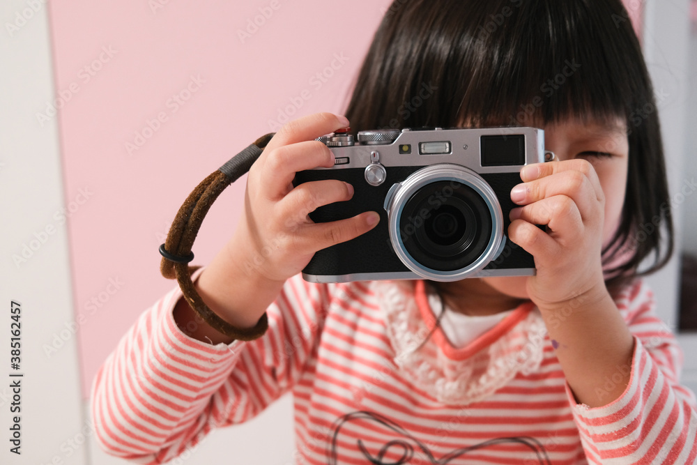 Asian little girl taking pictures with camera Asian little girl taking pictures with camera