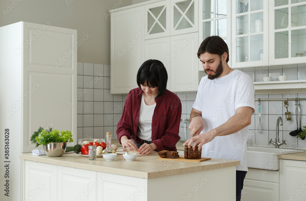 Happy couple cooking in kitchen together Happy couple cooking in kitchen together