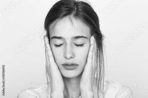 Portrait of a girl touching her face in black and white