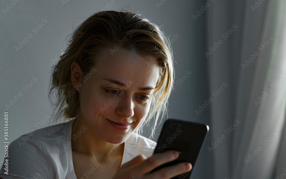 Woman in the morning uses a smartphone in bed. Woman in the morning uses a smartphone in bed.