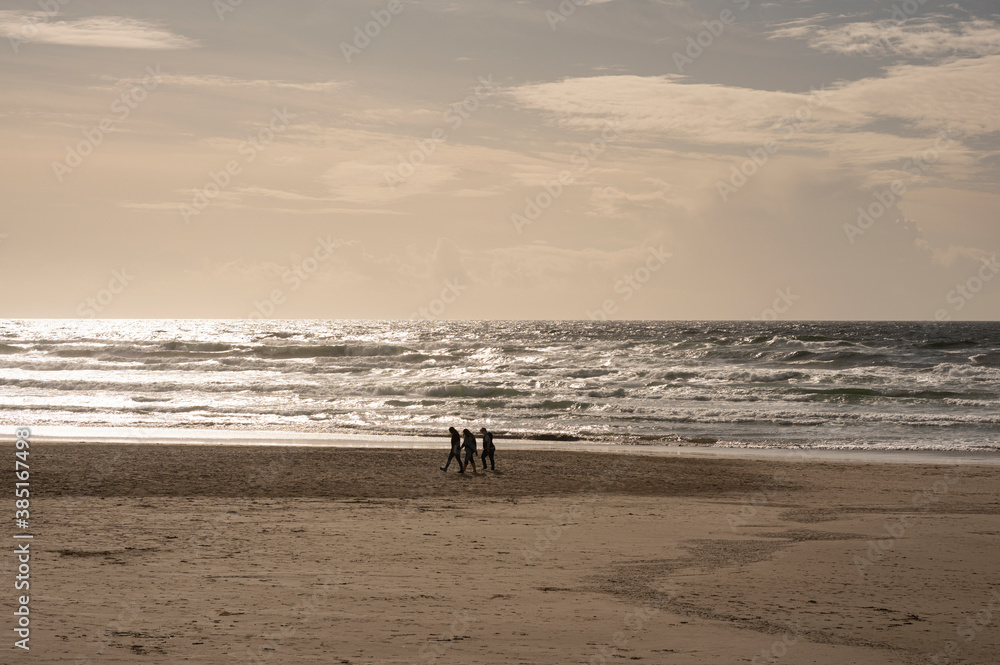 Three Silhouettes Walking on the Beach on the Oregon Coast in Autumn