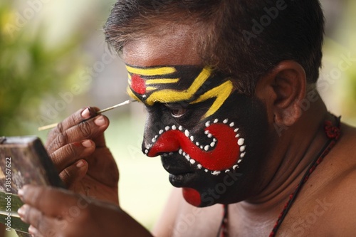 Kathakali dancer doing his make up, Chuvanna Thaadi mask, Kerala, southern India, Asia photo