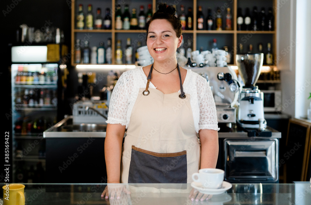 Smiling female owner with coffee on bar counter standing in cafe Smiling female owner with coffee on bar counter standing in cafe