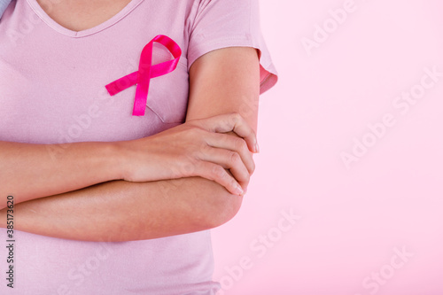 Wallpaper Mural close up of woman in with pink breast cancer awareness ribbon isolated on pink blank copy space studio background,healthcare,medicine concept Torontodigital.ca
