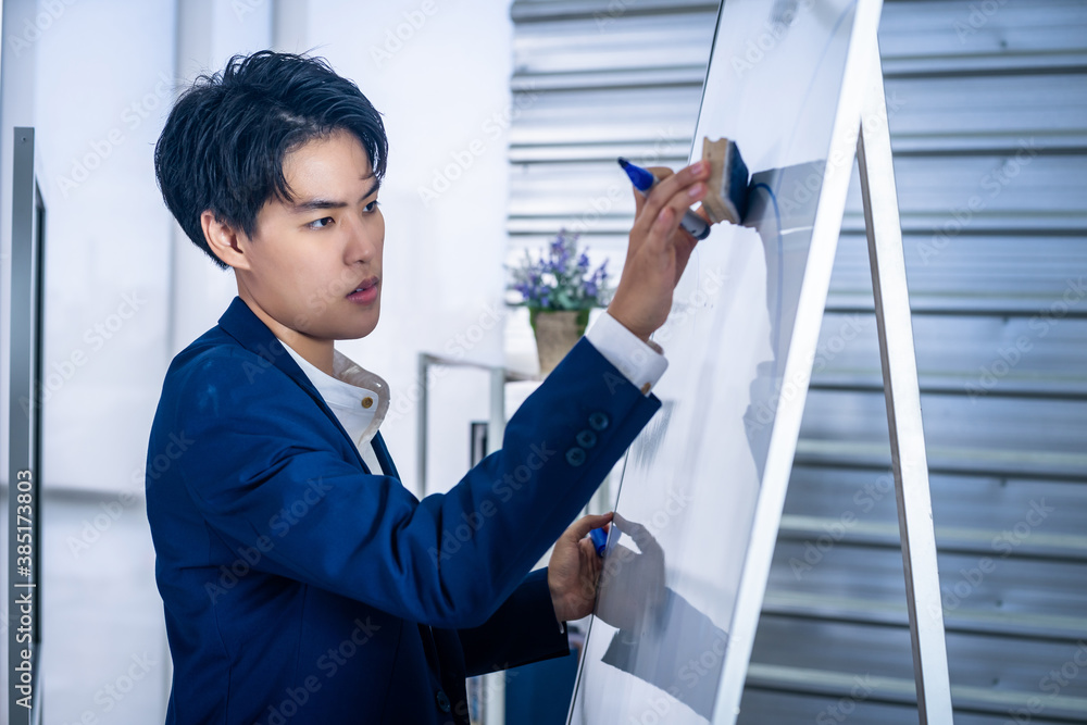 Asian Young Business tomboy lesbian putting his ideas on white board during a presentation in front of whiteboard in the room at office