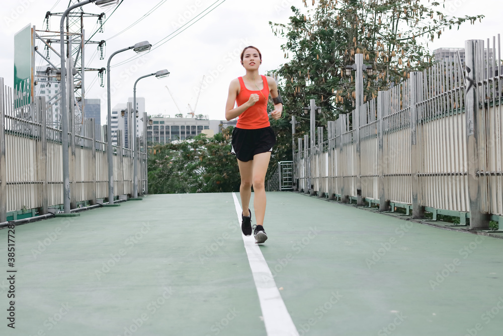 Fototapeta premium Young Asian healthy female running on street. Fitness and exercise concept.