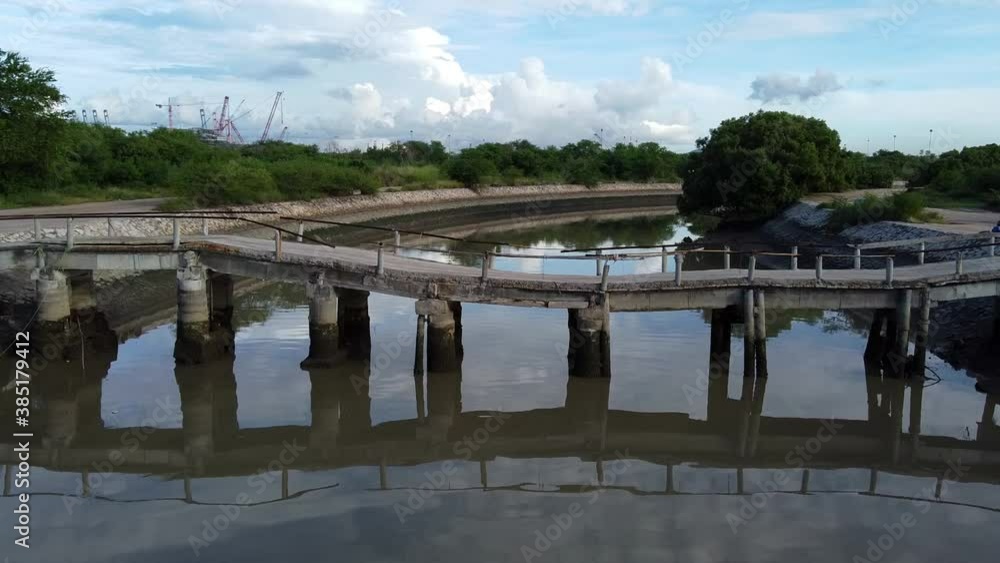 Fly low and close over wonky canal bridge at SE Asian fishing community Fly low and close over wonky canal bridge at SE Asian fishing community