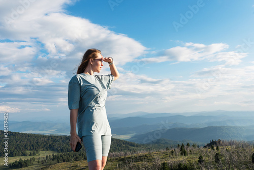 Domestic tourism, travel, lesure and freedom concept after pandemic- woman on the top of Altai mountain, beauty summer evening landcape © olinchuk