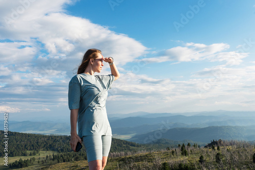 Domestic tourism, travel, lesure and freedom concept after pandemic- woman on the top of Altai mountain, beauty summer evening landcape