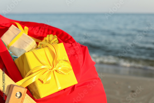 Santa Claus bag with gifts on beach, closeup