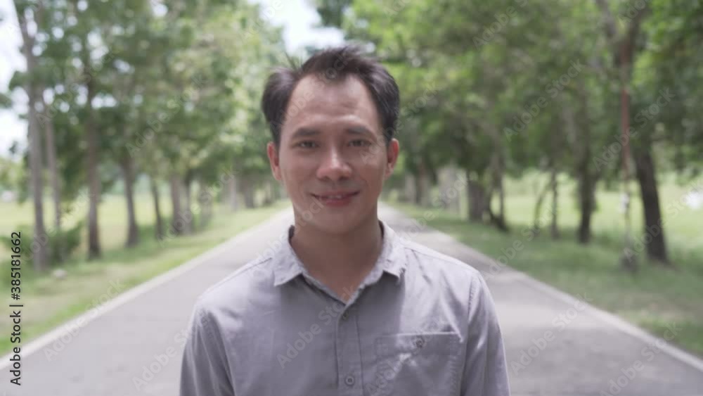 Good Looking Filipino Businessman Smiling While Walking In The Empty Road Toward Camera In The Philippines. - tracking shot Good Looking Filipino Businessman Smiling While Walking In The Empty Road Toward Camera In The Philippines. - tracking shot