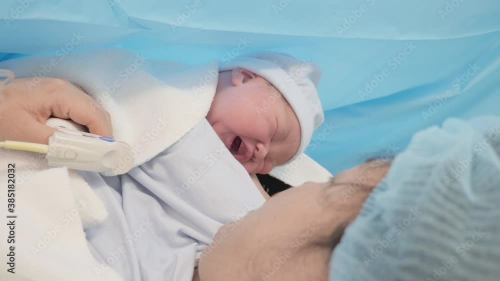 A newborn baby crying after birth and finding comfort with the skin