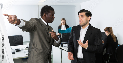 Schilderij op canvas Angry boss pointing his hand at exit in modern office, dismissing frustrated mal