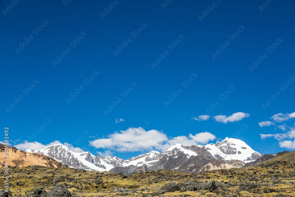 Nevados y montañas andinas con cielo azul 
