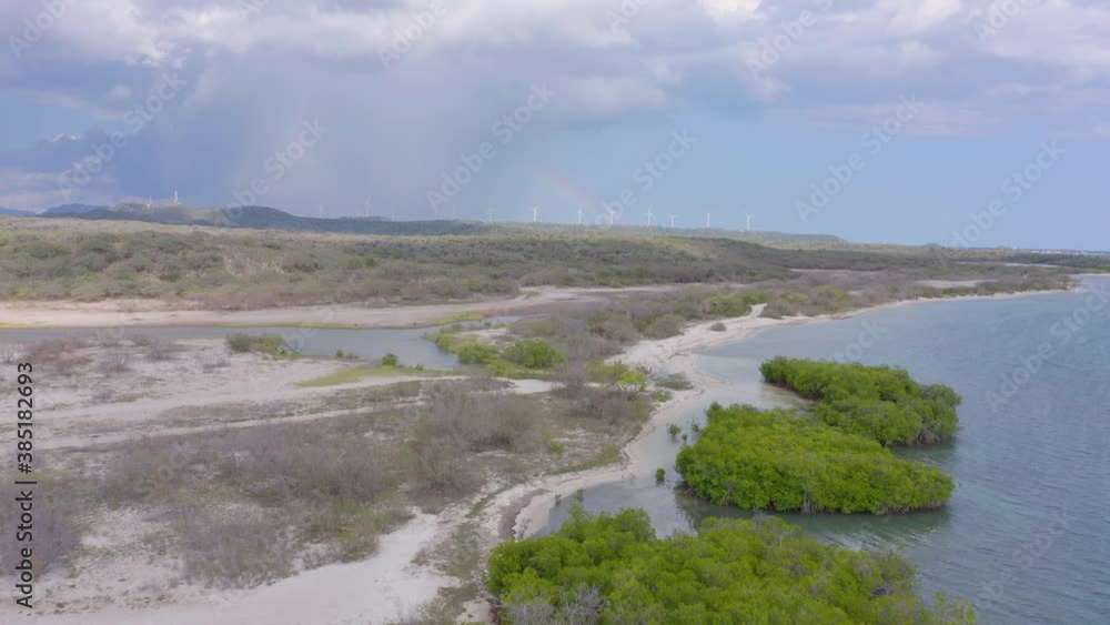 Aerial forward view of mangroves with rainbow and wind turbines in background. Sabana Buey Aerial forward view of mangroves with rainbow and wind turbines in background. Sabana Buey