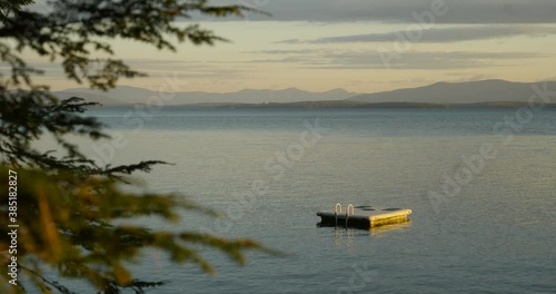 Scenic shot swimming platform floating in lake calm waters, Gilford, New Hampshire photo