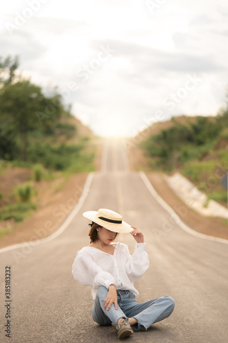 Woman alone in beautiful empty rural curve, asphalt road way.