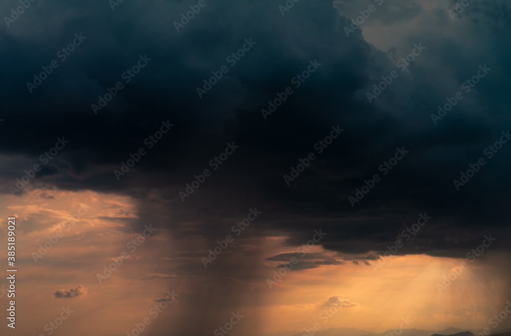 Naklejka premium Dark dramatic sky and clouds. Background for death and sad concept. Golden sunlight and black clouds. Thunder and storm sky. Sad and moody sky. Nature background. Dead abstract background. Cloudscape.