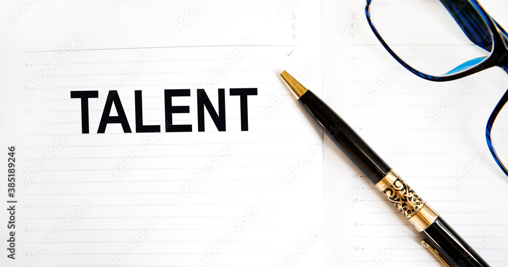 In the notebook inscription TALENT, next to glasses and a pen. In the notebook inscription TALENT, next to glasses and a pen.
