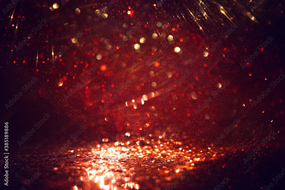 Naklejka premium background of abstract red, gold and black glitter lights. defocused