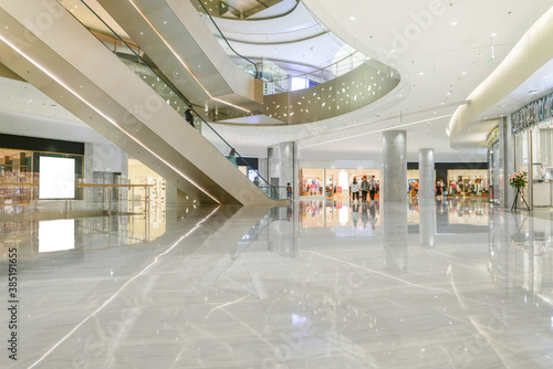 Hall of modern shopping mall with storefronts.