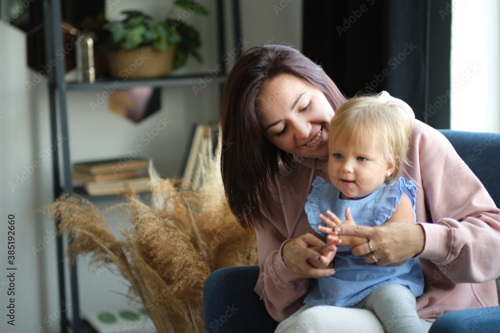 mom and little child are sitting in the studio in the living room and playing together. happy motherhood. education by love. mom and little child are sitting in the studio in the living room and playing together. happy motherhood. education by love.