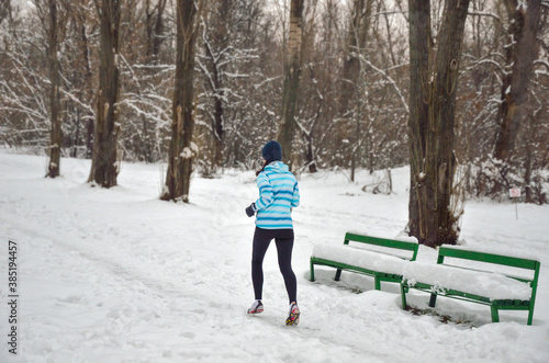 Active happy woman runner jogging outdoors in snowy park in winter, healthy lifestyle, sport and running concept  © Iuliia Sokolovska