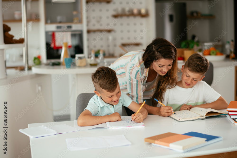 Mother helping her son with homework at home. Little boy learning at home... Mother helping her son with homework at home. Little boy learning at home...