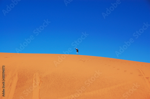 Man walking on beautiful dune of Namib desert, traveling and hiking in South Africa 