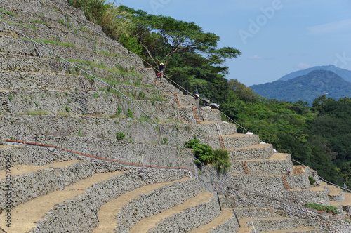 石積みの段々畑を耕す人物 photo