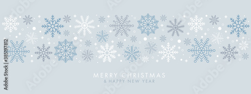 Merry Christmas and Happy New Year festive design with border made of beautiful snoflakes in modern line art style. Winter blue background with falling snow. Xmas decoration. Vector illustration.