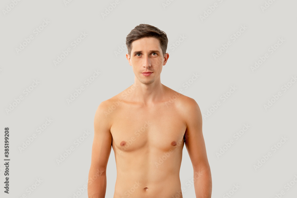 Obraz premium Handsome shirtless man. Healthy lifestyle. Male body care. Hygiene grooming. Attractive athletic guy looking at camera isolated on white copy space background.
