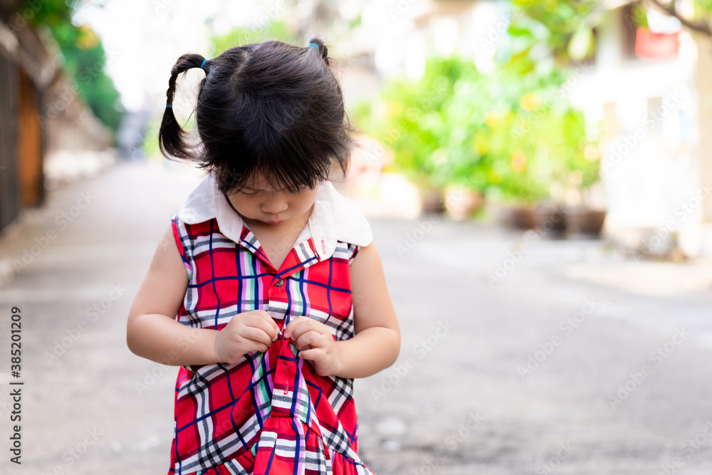 Selective focus hands girl. Child in red dress is buttoning shirt ...