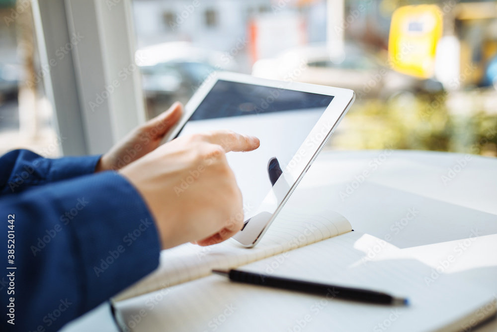 Closeup of a businessman hands with a tablet. Young man sits in a cafe and checking the pictogram graph on a tablet. Working leading business from a distance and remotely. Heath care concept.