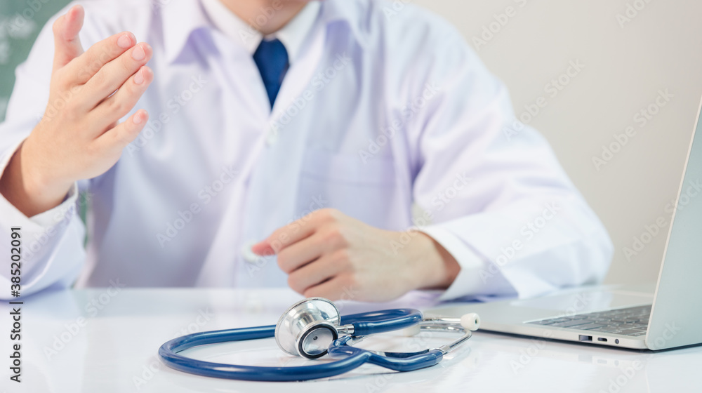 Medicine doctor's working on desk. Closeup of Stethoscope. Physician man video call raise hands explain patient understand on table front computer monitor at hospital office, Healthcare medic concept Medicine doctor's working on desk. Closeup of Stethoscope. Physician man video call raise hands explain patient understand on table front computer monitor at hospital office, Healthcare medic concept