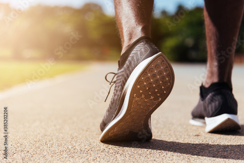 Asian young athlete sport runner black man wear feet active ready to running training at the outdoor on the treadmill line road for a step forward, healthy exercise workout, closeup back shoe