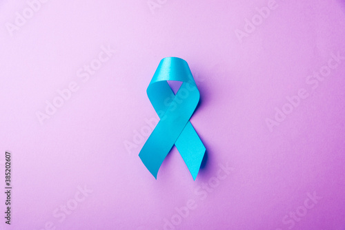 November light blue ribbon, studio shot isolated on purple background, Prostate cancer awareness month, men's health concept photo