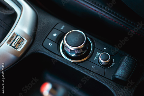 modern car media and navigation control buttons and regulator. black leather with red line interior details. close up © Karine_k.a